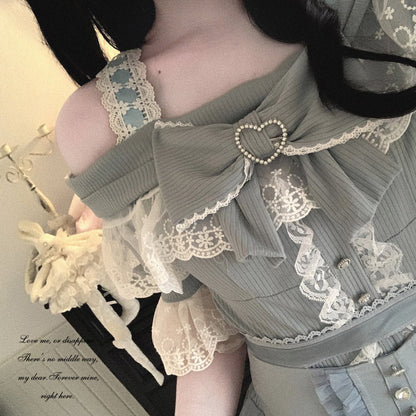 Person wearing a detailed dress with lace and embroidery, holding a small object.