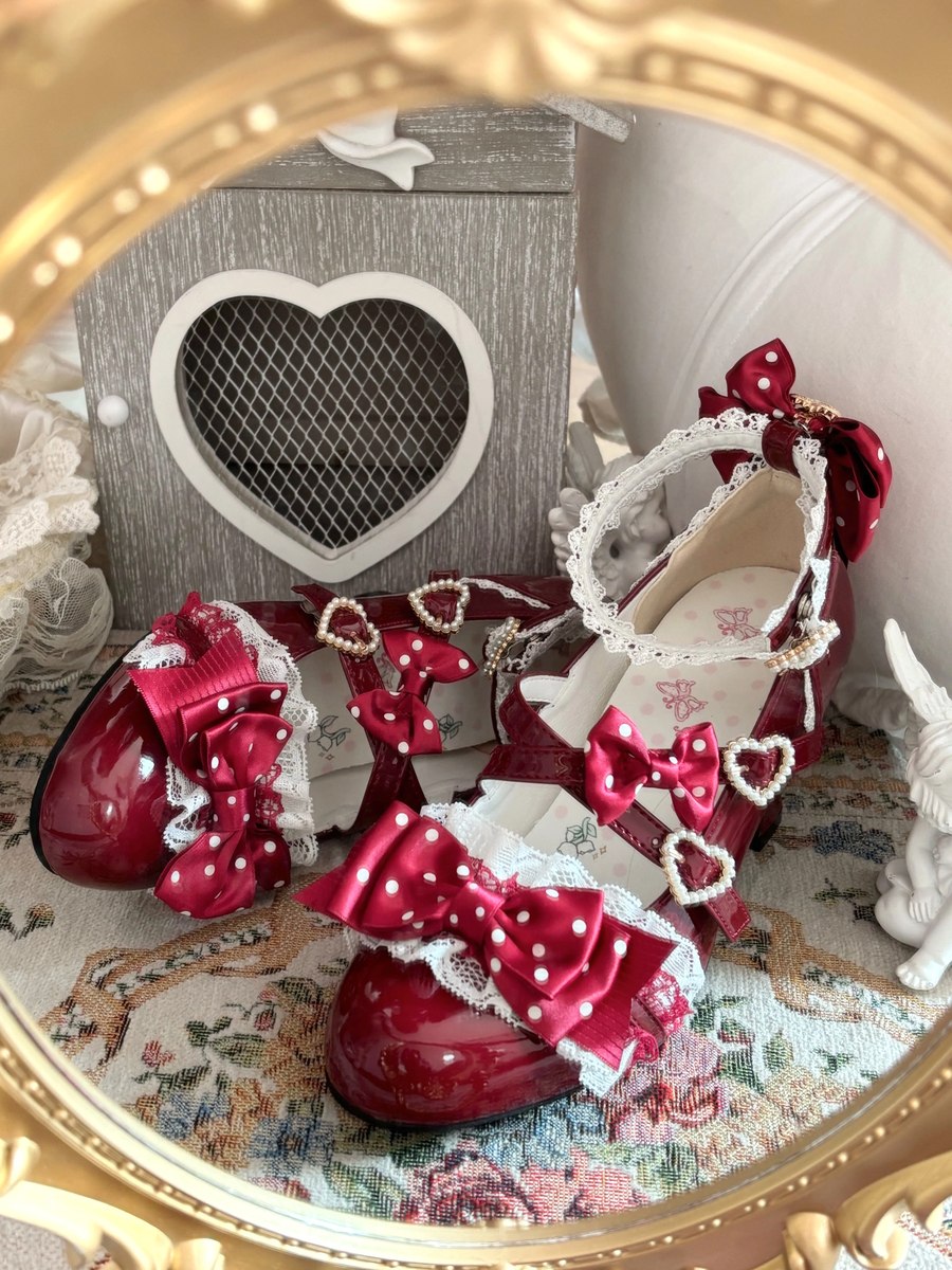 Red mary jane shoes with heart details on a decorative surface