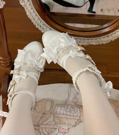White lace shoes with decorative bows on a wooden chair.