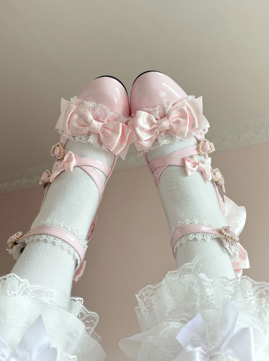 Pink shoes with bows and white ruffled stockings on a neutral background