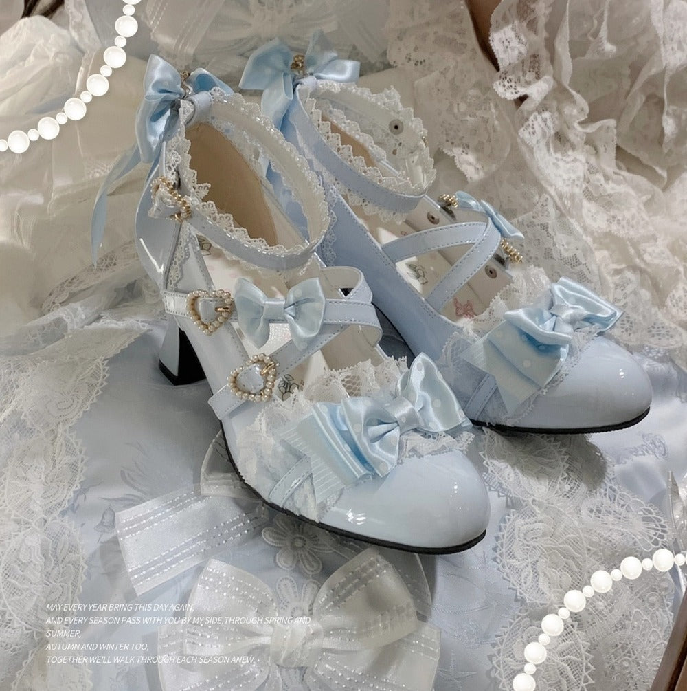 Pair of white high-heeled shoes with decorative bows on a lace background