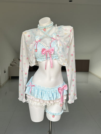 A pastel Lolita-style lingerie set displayed on a white mannequin torso in a room. The set includes a white long-sleeve top with pink and light blue floral patterns, a light blue ruffled crop top with pink bows, matching light blue ruffled bottoms, and a leg band.