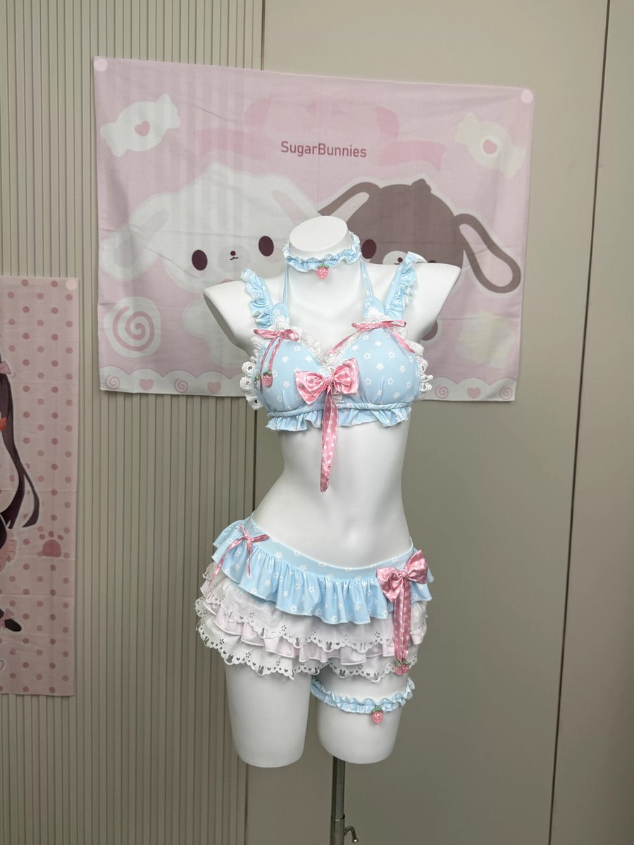 A light blue and white polka dot two-piece lingerie set with pink bows and ruffles, displayed on a white mannequin torso. The set includes a ruffled halter top and matching ruffled shorts.