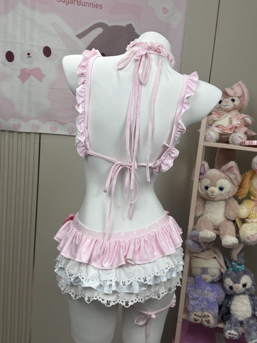 A pink and white ruffled lingerie-style dress displayed on a white mannequin torso, photographed indoors. The back view shows a halter-style top with tie straps and layered ruffles at the waist.