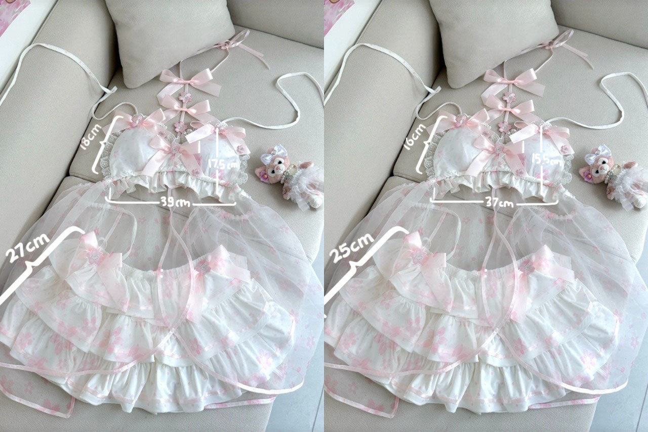 A babydoll lingerie set with a sheer white and pink floral mesh skirt and a matching ruffled bralette, displayed on a beige sofa with measurement annotations.