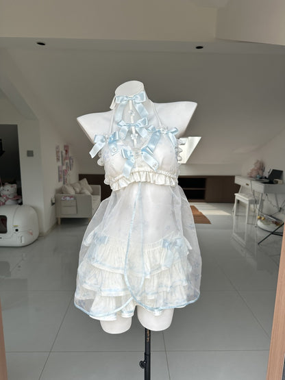 A white and light blue ruffled halter dress displayed on a white mannequin torso in a home interior setting.
