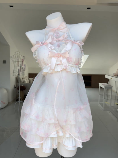 A white and pale pink halter babydoll dress with ruffles and bows, displayed on a white mannequin in a bright indoor room.