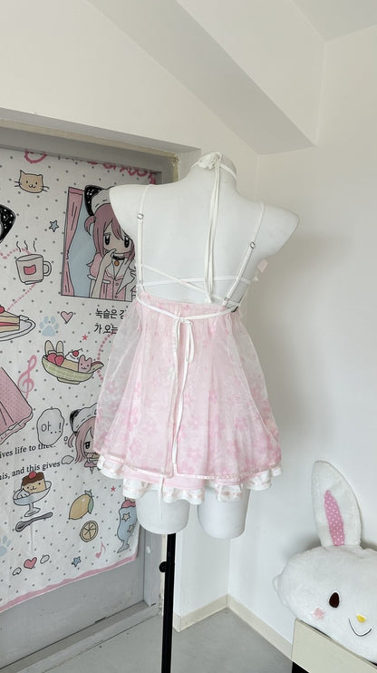 A pink lace-trim halter dress displayed on a white mannequin torso in a room corner. The dress has a sheer mesh overlay and ruffled lace hem.