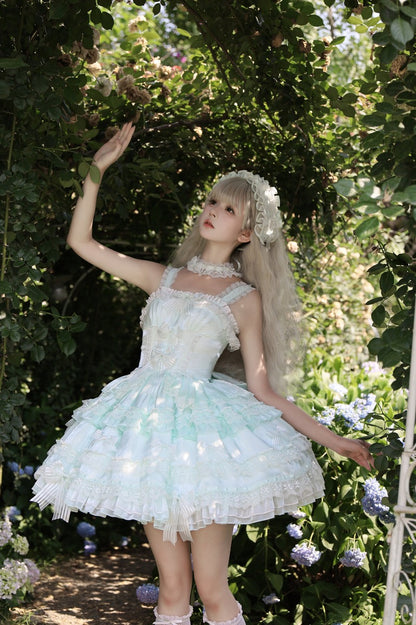 Woman in a white dress with floral decorations standing in a garden.
