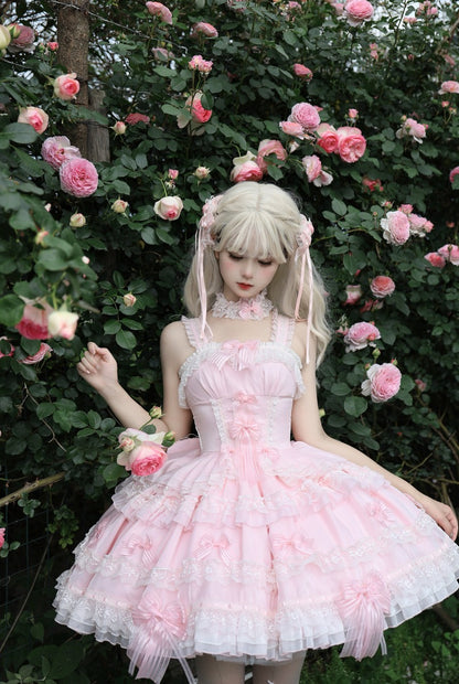 Person in a pink floral dress standing among pink flowers and greenery