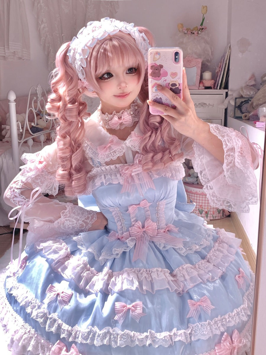 Person in a detailed and colorful outfit with pink hair, taking a selfie.