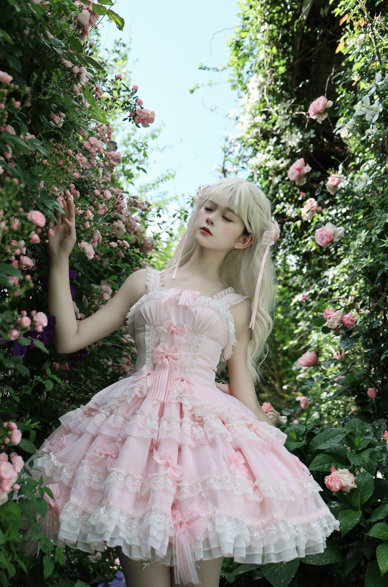 Woman in a pink dress standing among flowers