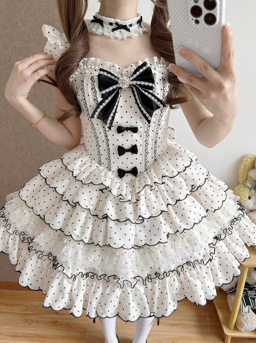 Person wearing a white dress with black bows and polka dots, taking a mirror selfie.