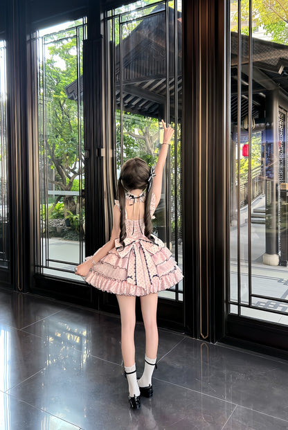 Woman in a pink dress standing in front of large glass doors with a garden view.