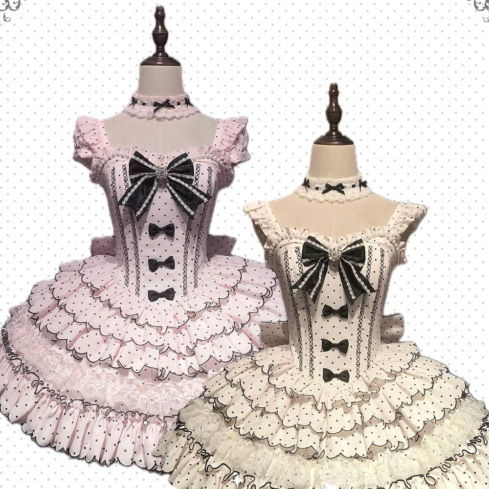 Two mannequins wearing pink and white dresses with black bows on a white background