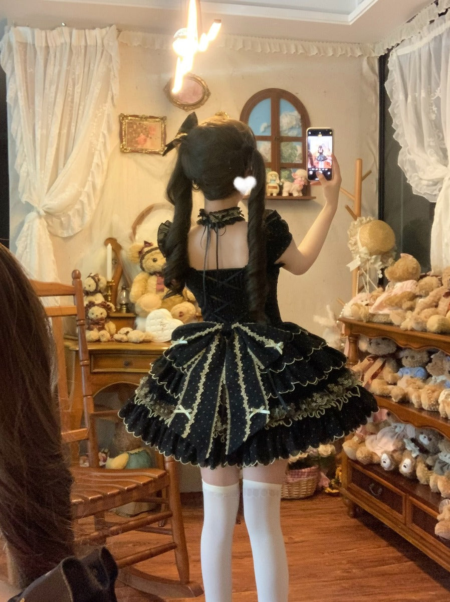 Person in a black and gold dress taking a selfie in a room with stuffed animals and decor.