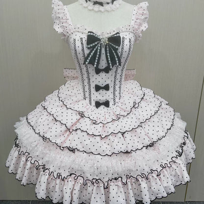Pink polka dot dress with black details on a mannequin against a plain background