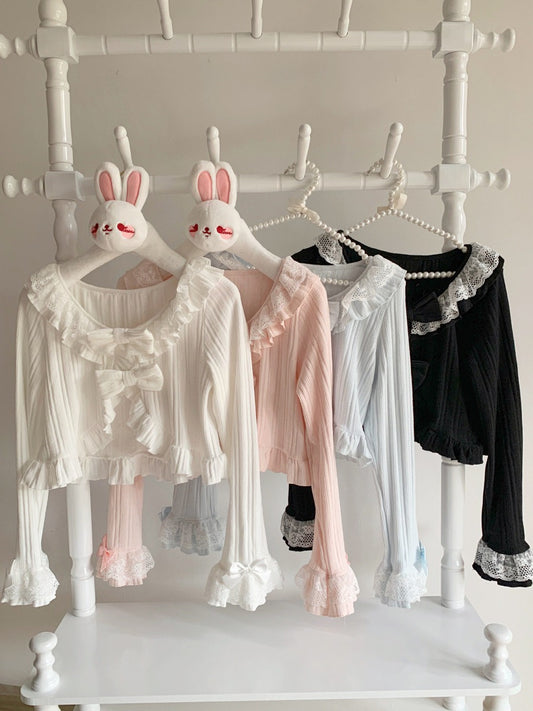 Cute pastel lolita style cardigan on hangers with bunny ears on a white rack.