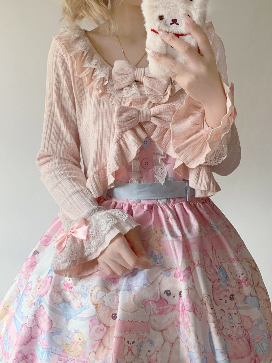 Person wearing a pastel pink and white outfit with a teddy bear and bow details.