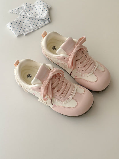 Pair of pink and white sneakers shoes on a light background