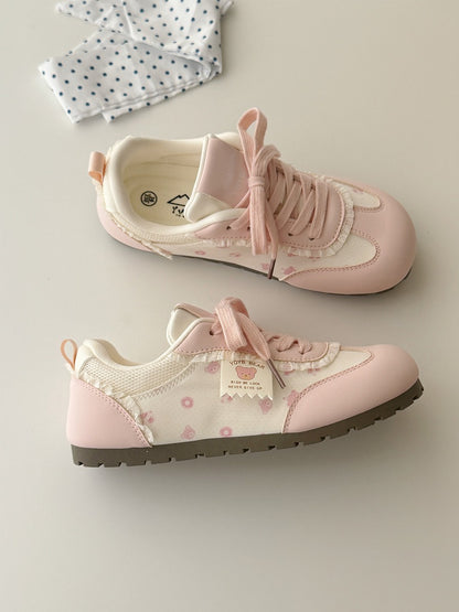 Pair of pink children's sneakers on a light gray background