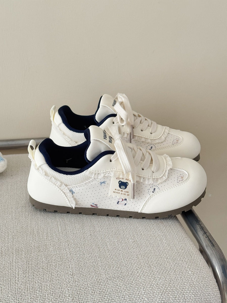 White sneakers with blue soles on a chair against a beige wall
