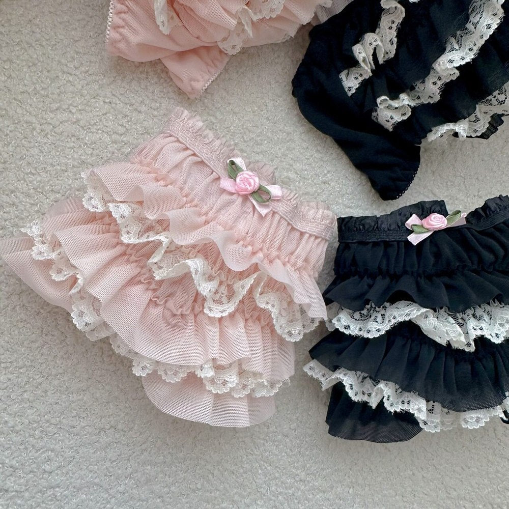 Pink and black ruffled bloomers with lace details on a light background