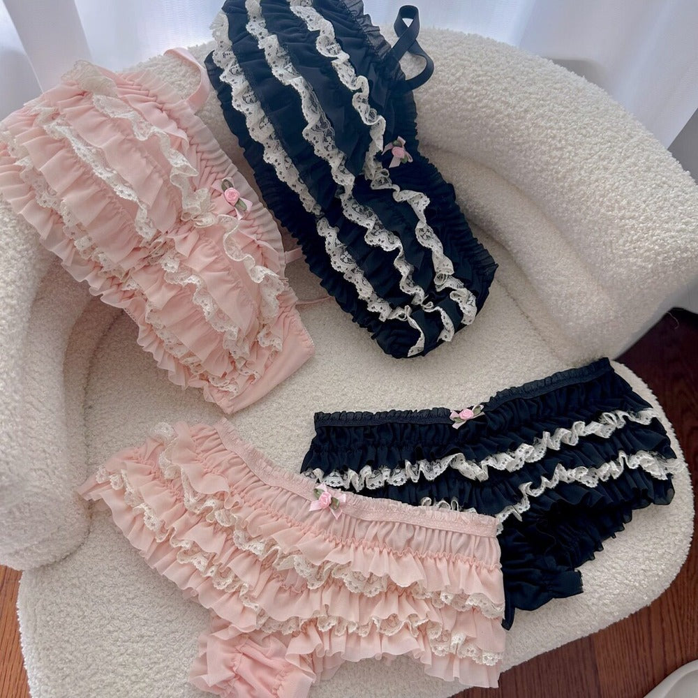 Pair of pink and navy ruffled bloomers on a textured surface.