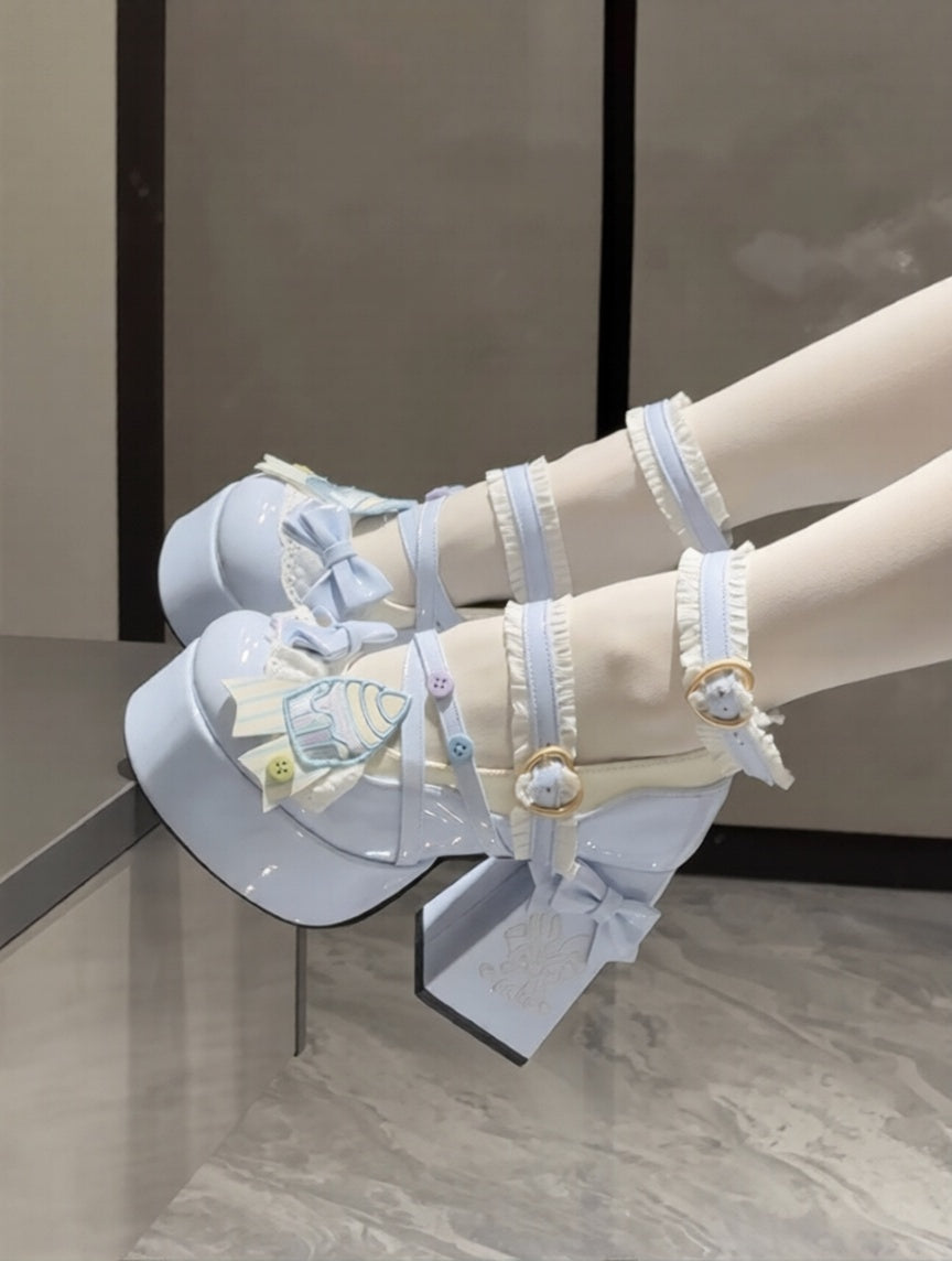 Light blue sandals with cute cupcake decorative bows on a neutral background