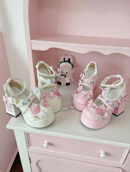 Pair of white and pink high-heeled shoes on a white surface with a pink background