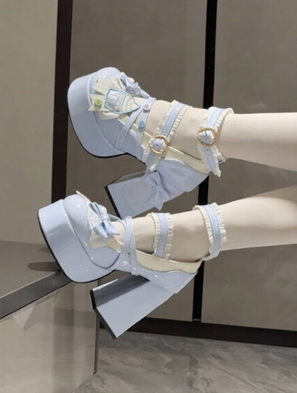 Light blue high-heeled shoes with cute cupcake decorative straps and a matching hat on a neutral background