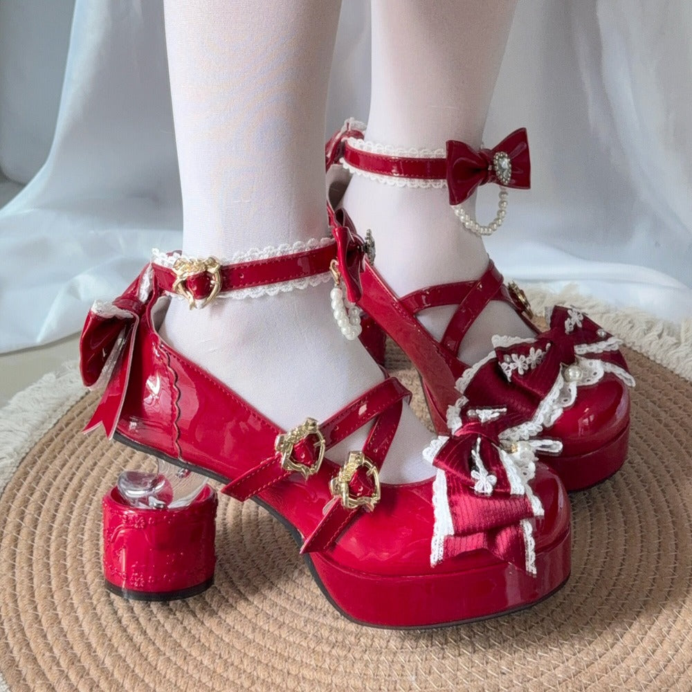 Red platform heels with decorative bows and pearls on a white background