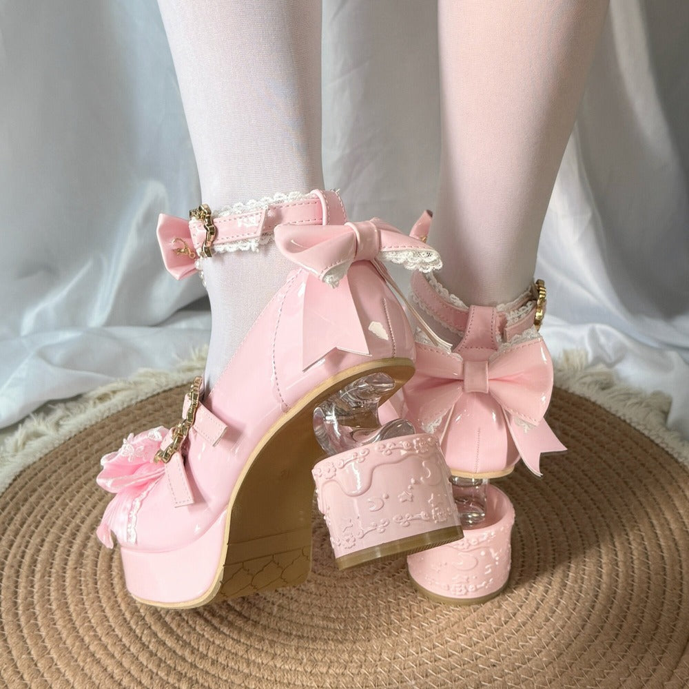 Pink high-heeled shoes with floral details on a white background