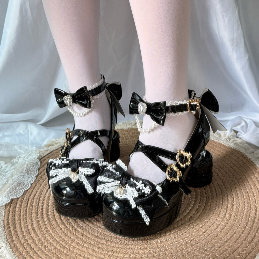 Black shoes with decorative bows and pearls on a white background