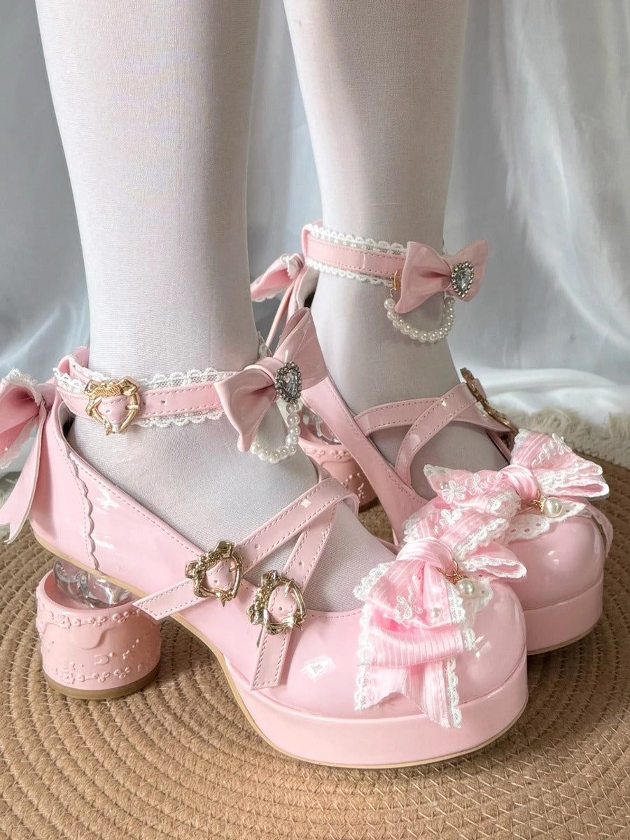 Pink platform shoes with decorative bows and ribbons on a neutral background