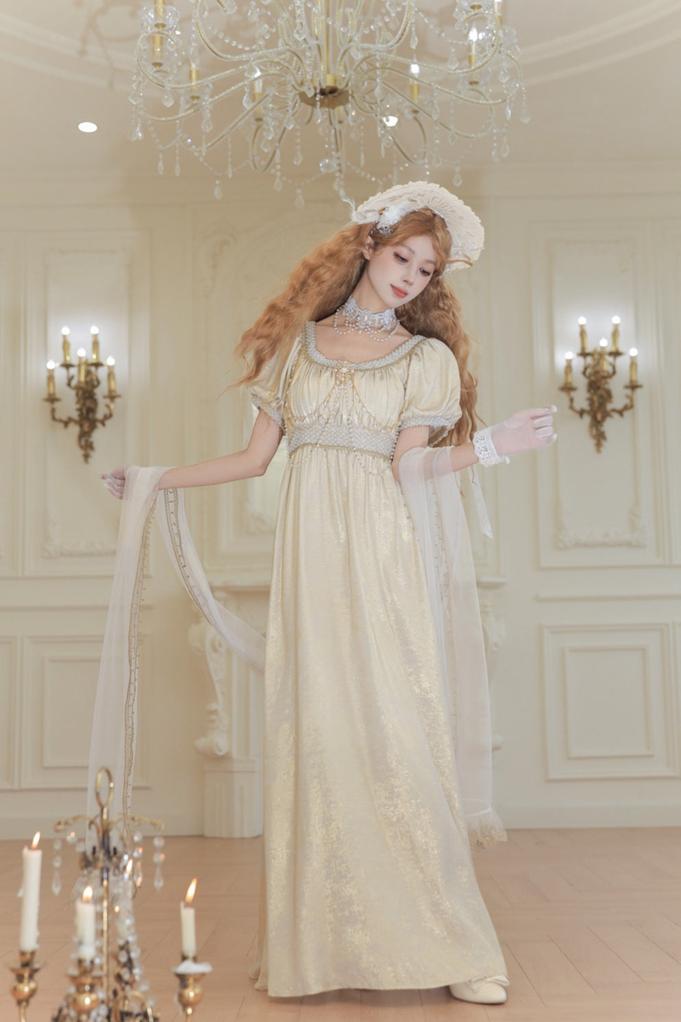 Woman in a vintage-style dress with a chandelier and candles in the background