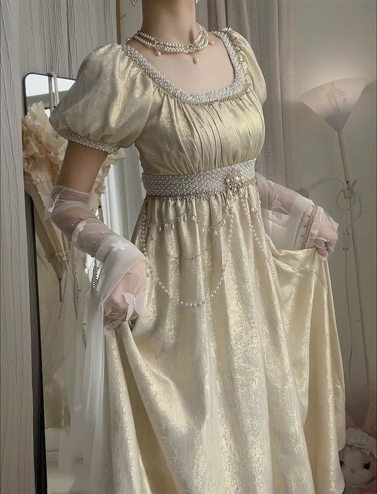 Person wearing a vintage-style beige dress with intricate details, standing in front of a mirror.