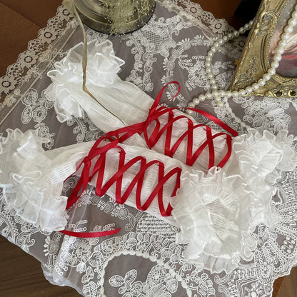 Red lace arm warmers with red on a lace tablecloth