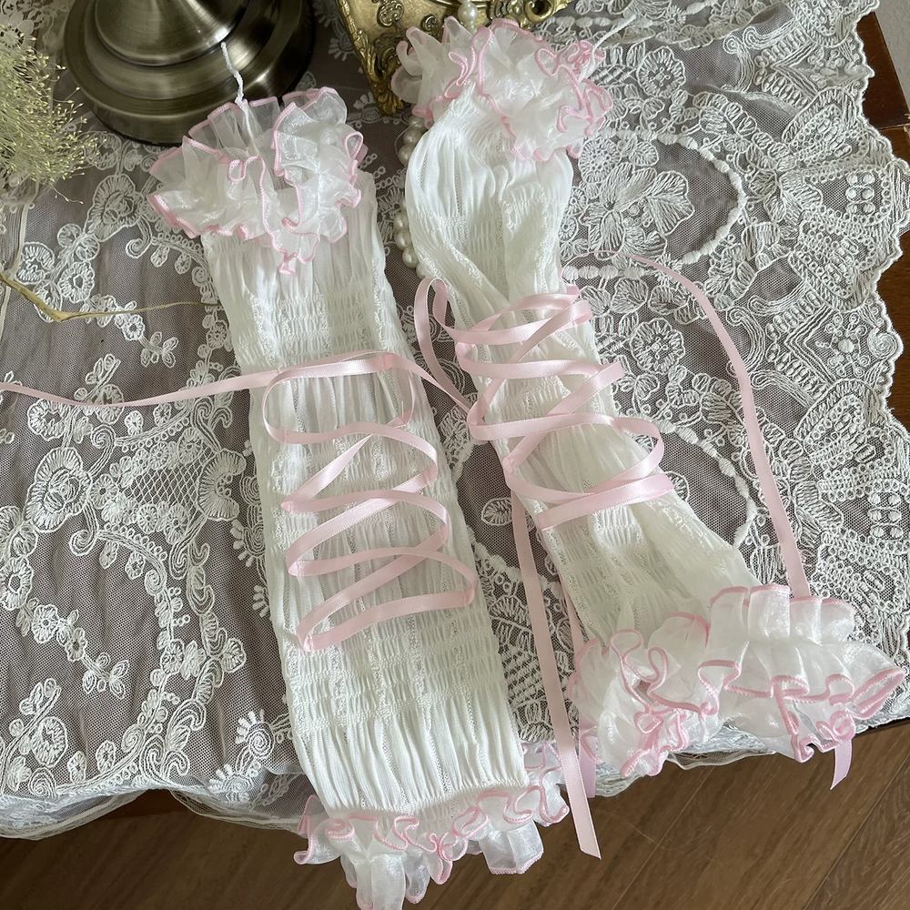 White lace garter with pink ribbons on a lace surface