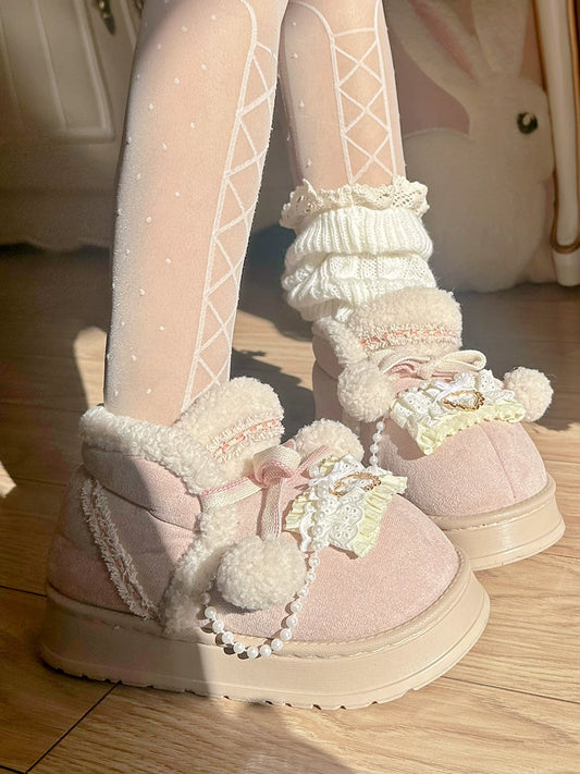 Pink fuzzy boots with decorative elements on a wooden floor.