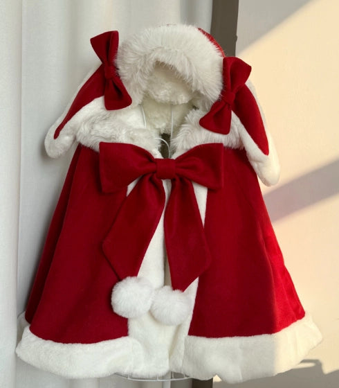Red coat with white fur trim and large bows on a mannequin against a neutral background