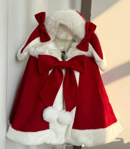 Red coat with white fur trim and large bows on a mannequin against a neutral background