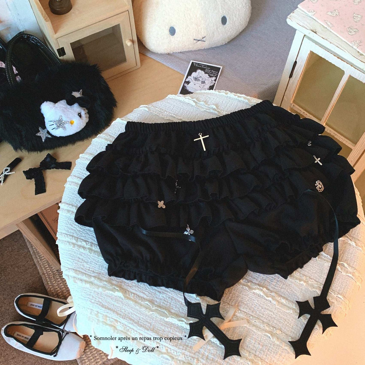 Black ruffled bloomers with decorative elements on a textured surface.