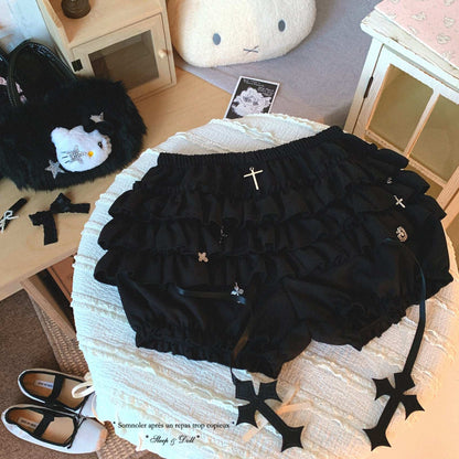 Black ruffled bloomers with decorative elements on a textured surface.