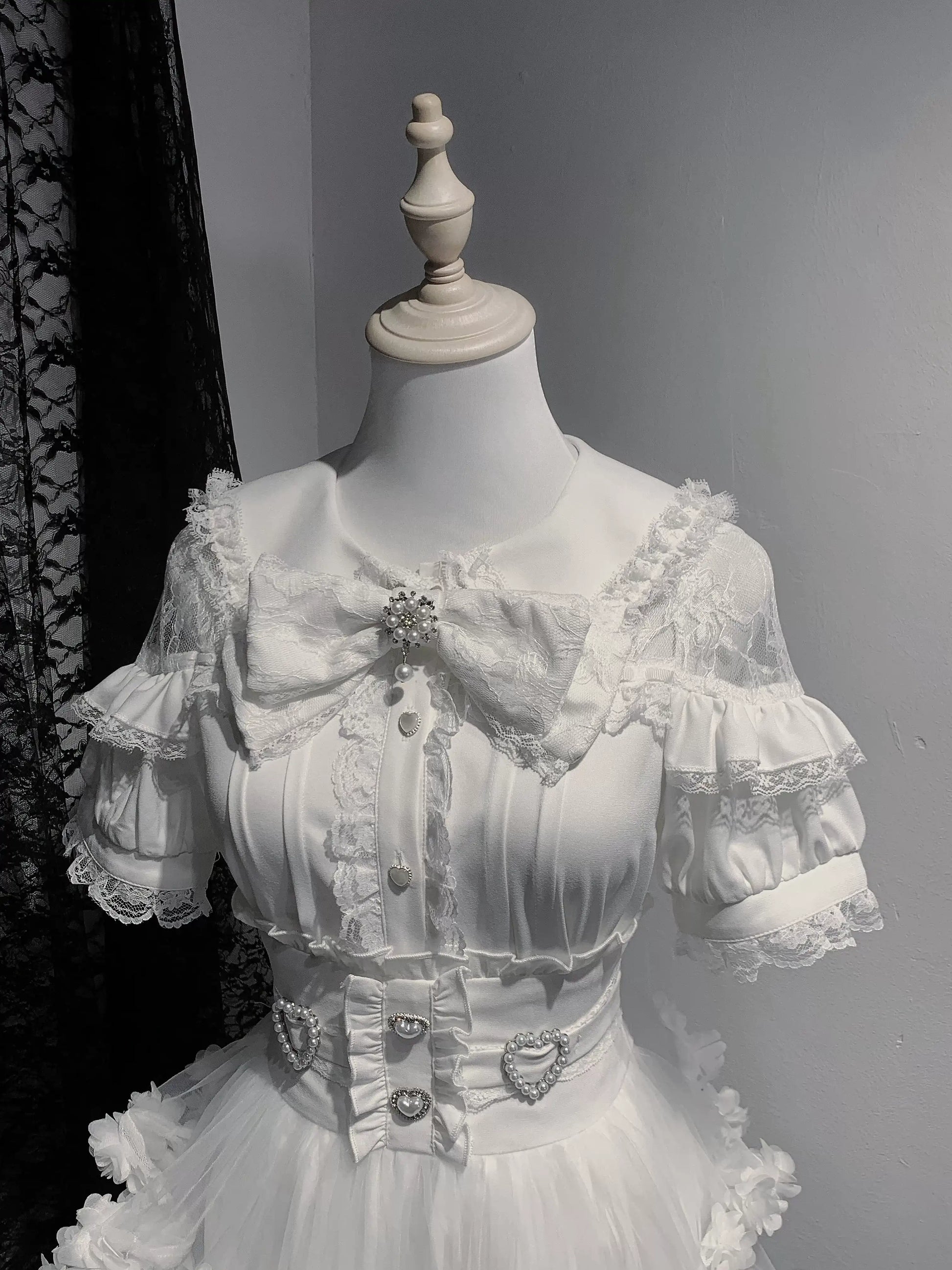 White lace dress on a mannequin against a gray background