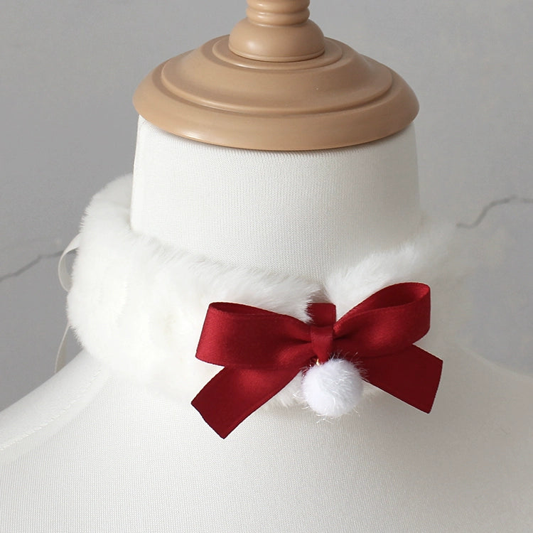 Mannequin head with a white fur collar and red bow on a plain background