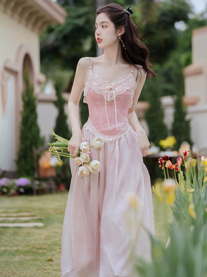 Woman in a pink dress holding flowers in a garden setting