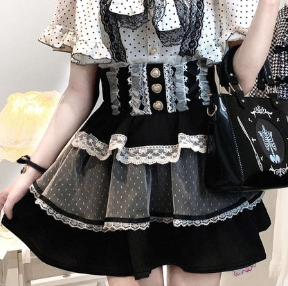 Person wearing a jirai kei black and white polka dot dress with lace details, holding a black handbag.