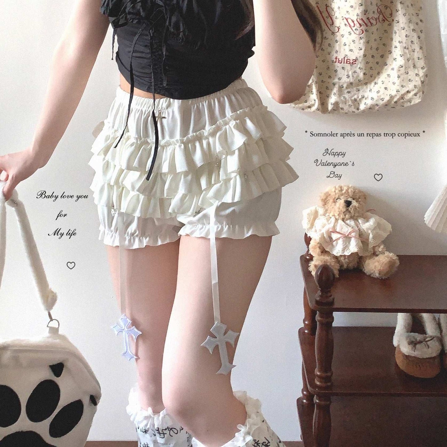 Person wearing a white ruffled skirt with a teddy bear and decorative items in the background.