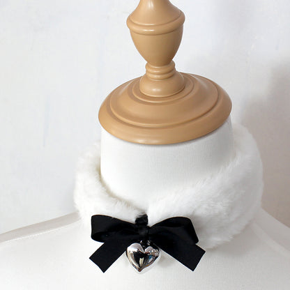 White fur collar with a black ribbon and silver heart charm on a white background